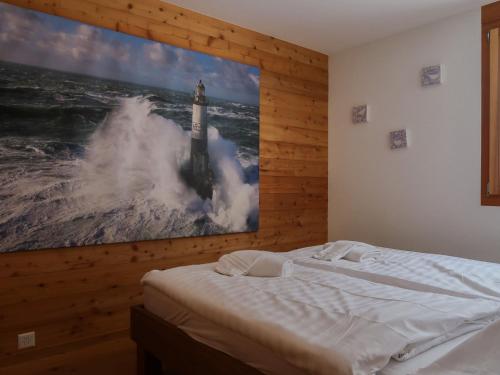 a bedroom with a picture of a lighthouse in the ocean at Apartment Rosablanche E003A by Interhome in Siviez