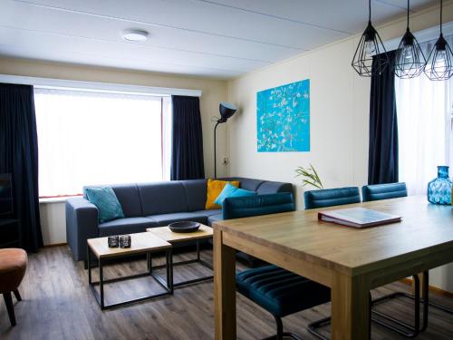 sala de estar con sofá azul y mesa en Holiday Home Duinhoeve-1 by Interhome, en Udenhout