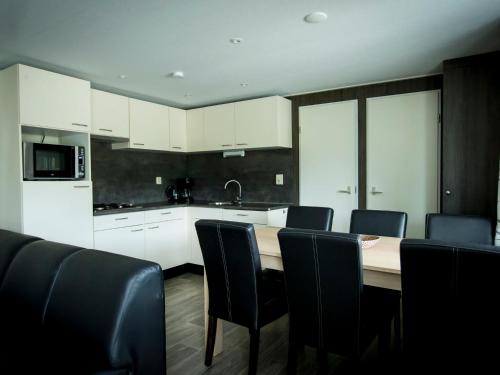 uma cozinha com mesa e cadeiras num quarto em Holiday Home Duinhoeve-1 by Interhome em Udenhout