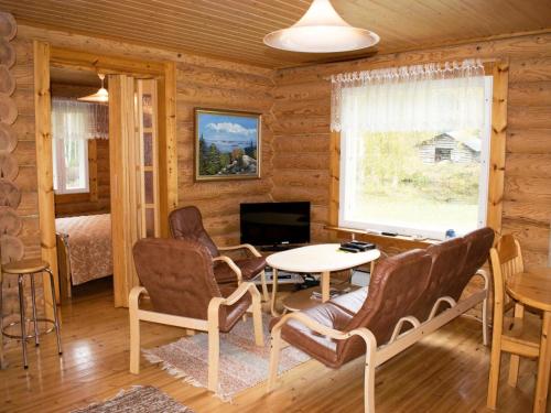 a log cabin living room with a table and chairs at Holiday Home Metsälä by Interhome in Kolinkylä