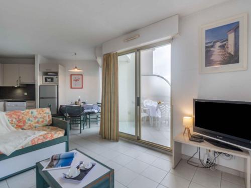 un salon avec un canapé et une télévision et une cuisine dans l'établissement Apartment L'Open-18 by Interhome, à Fréjus