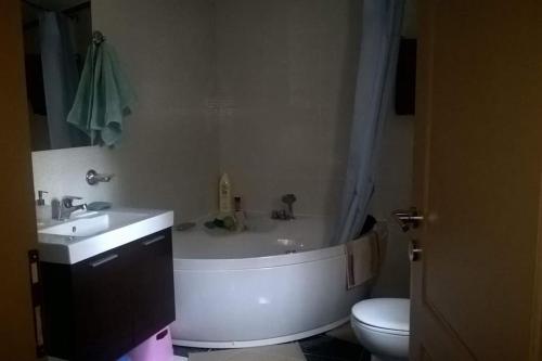 a bathroom with a tub and a sink and a toilet at Villa Evelina in Kalamata