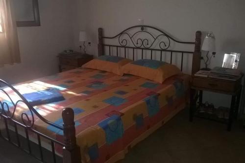 1 dormitorio con 1 cama grande y edredón colorido en Villa Evelina en Kalamata