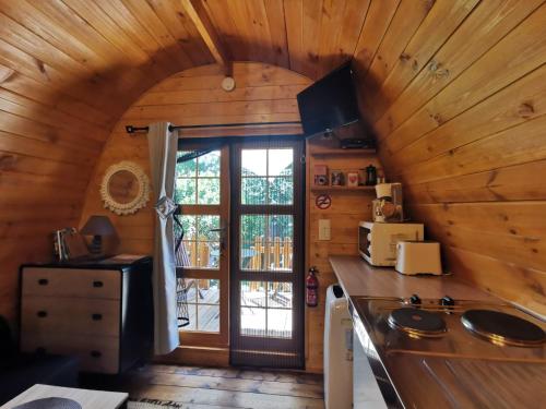 a kitchen with wooden walls and a large window at Ma cabane au fond du jardin in Porto-Vecchio