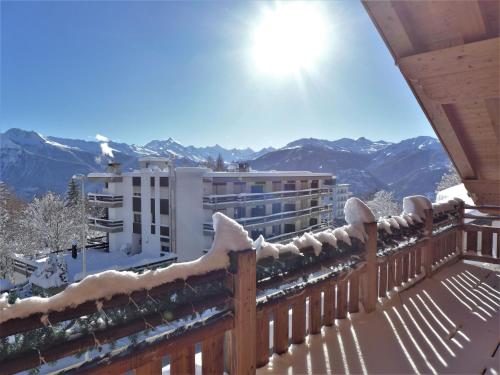 a snow covered balcony with a view of mountains at Chalet Chalet Astoria by Interhome in Crans-Montana