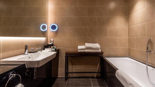 a bathroom with a sink and a bath tub at InterContinental London - The O2 in London