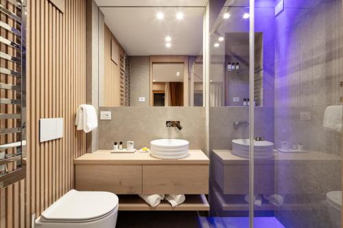 a bathroom with a toilet and a sink and a shower at Campiglio WOOD in Madonna di Campiglio