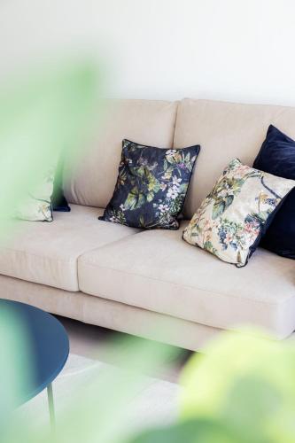 a couch with four pillows on it at Hamilius Apartments City Center Luxembourg by Rentaroo in Luxembourg