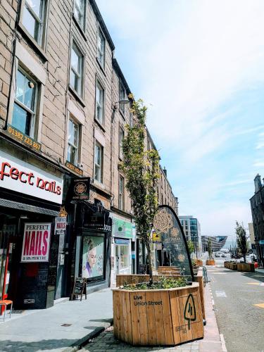 a city street with a large wooden barrel with a tree in it at aabAlree Guest House in Dundee