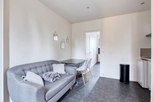 sala de estar con sofá y mesa en Le Lilas Appart Hôtel Near Paris, en Vitry-sur-Seine