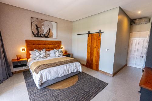a bedroom with a large bed with a wooden headboard at Beach Wood Boutique Hotel & Resort in Ballito