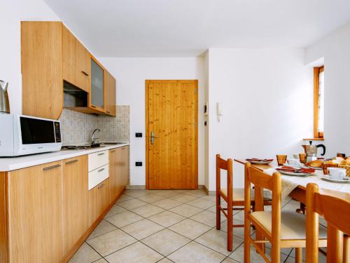 cocina con mesa con sillas y microondas en Apartment Al Pescatore-6 by Interhome, en Bordiana