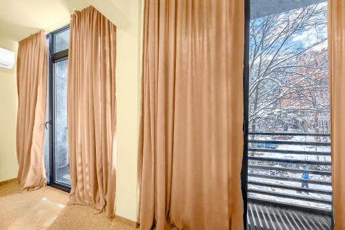 a room with curtains and a large window at LALO Hotel Abastumani in Abastumani