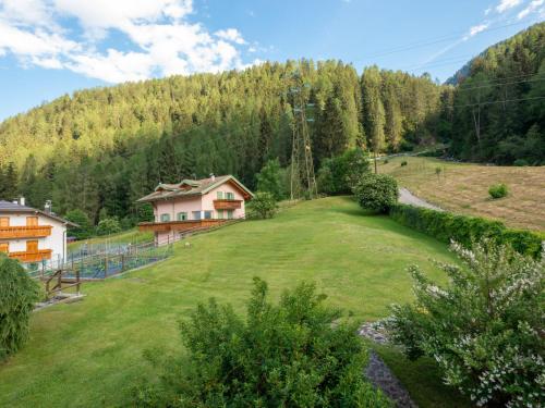 a large green yard with a house and a mountain at Villa Villa Lucia by Interhome in Pellizzano