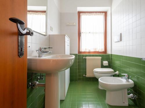 a green bathroom with a sink and a toilet at Villa Villa Lucia by Interhome in Pellizzano