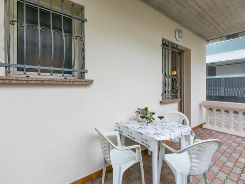 a white table and chairs on a patio at Apartment Guglielmo e Anna by Interhome in Lignano Sabbiadoro