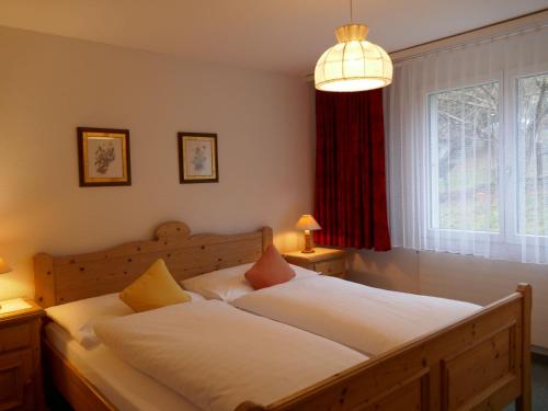 um quarto com 2 camas e uma grande janela em Apartment Chalet Wyssefluh by Interhome em Grindelwald