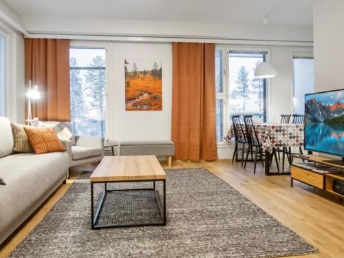 ein Wohnzimmer mit Sofa und Fernseher in der Unterkunft Holiday Home Jymykatti by Interhome in Vuokatti