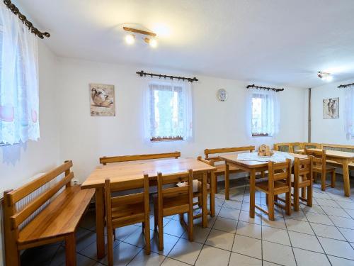 un comedor con mesas y bancos de madera en Holiday Home Zlatá Olešnice 122 by Interhome en Zlatá Olešnice