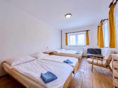 a bedroom with two beds and a chair in it at Holiday Home Zlatá Olešnice 122 by Interhome in Zlatá Olešnice