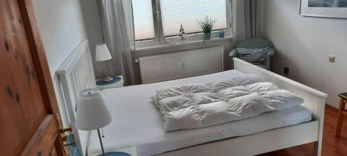 uma cama branca num quarto com uma janela em Ferienhaus Diana em Scharbeutz