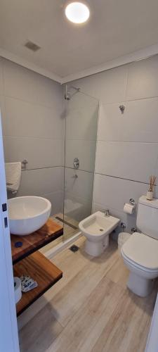 y baño con lavabo, aseo y ducha. en Infinito - Departamento con vista al mar en Comodoro Rivadavia