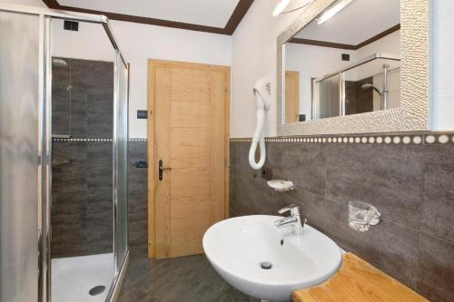 a bathroom with a sink and a shower and a mirror at Appartamento1 deluxe - Alpen Suite in Livigno