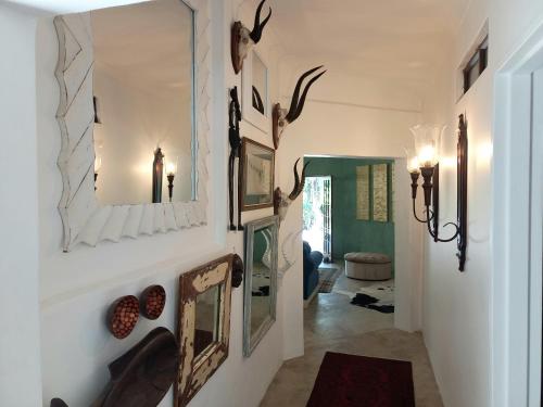a hallway with a mirror and antlers on the wall at Rock Fig Suite - Villa Roc Guesthouse in Salt Rock