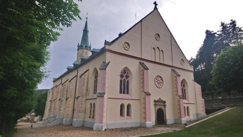 a large pink and white church with a steeple at Resort Abertham - penzion Ellen in Abertamy