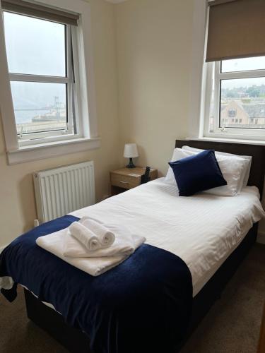 a bedroom with a bed with two towels on it at Caithness Inn in Wick