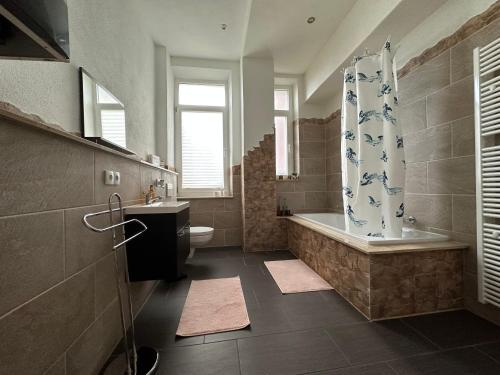 a bathroom with a tub and a toilet and a shower at Belle Vue Kaiser Apart in Fürth