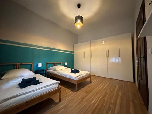 two beds in a room with green walls and wooden floors at Belle Vue Kaiser Apart in Fürth