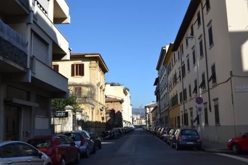 una calle de la ciudad con coches y edificios aparcados en Home Willy, en Florencia