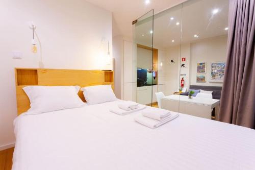 una camera da letto con un grande letto bianco e uno specchio di Cozy apartment in the center of Porto a Porto