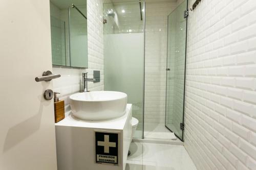 bagno bianco con lavandino e doccia di Cozy apartment in the center of Porto a Porto