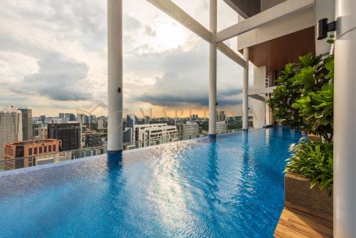 ein Schwimmbad auf dem Dach eines Gebäudes mit einer Stadt in der Unterkunft The Colony and The Luxe Premier Suites Kuala Lumpur in Kuala Lumpur