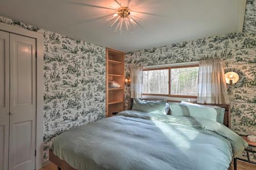 a bedroom with a bed and a chandelier at Cozy Woodstock Home with Fire Pit! in Woodstock