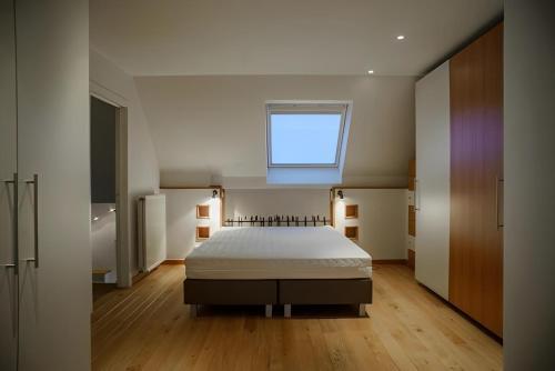 a bedroom with a bed with a window above it at Big and comfortable triplex in Knokke in Knokke-Heist