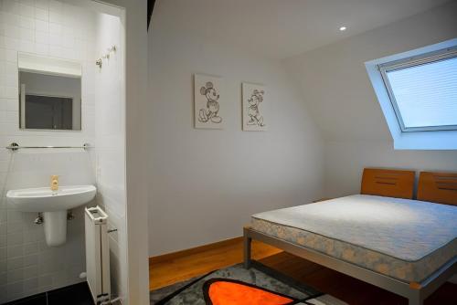 ein kleines Bad mit einem Bett und einem Waschbecken in der Unterkunft Big and comfortable triplex in Knokke in Knokke-Heist