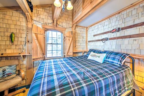 1 dormitorio con 1 cama en una habitación con paredes de madera en Palmyra Cottage with Deck on Whites Pond!, en Coburn