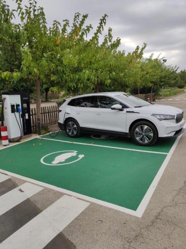 a white car is plugged into a gas pump at Hotel Sausa in Vilafreser