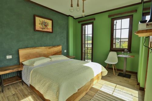 - une chambre avec des murs verts et un grand lit dans l'établissement Vila Strugu, à Voskopojë
