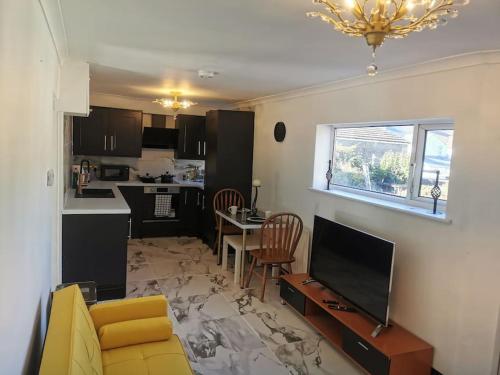 sala de estar con TV y cocina en Stylish and Modern Apartment close to Dover Port! en Kent