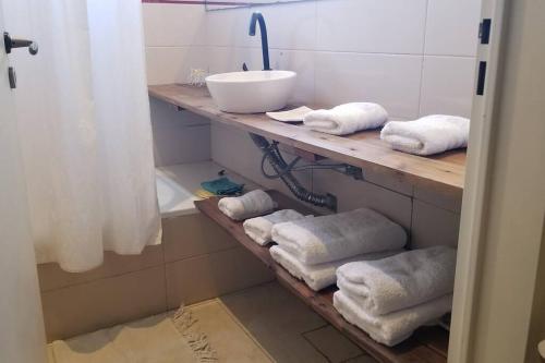 baño con lavabo y estante con toallas en Hermosa casa con fogonero, parrilla cubierta, pileta y jardin parquizado en Benavídez