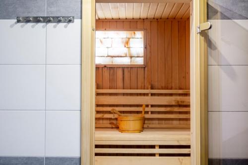 a wooden door in a sauna with a bucket at Penzion Blatnička in Blatnička