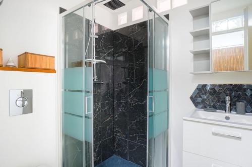 a glass shower in a bathroom with a sink at LeRouget : Hypercentre / Jardin aménagé / Hamak in Moissy-Cramayel
