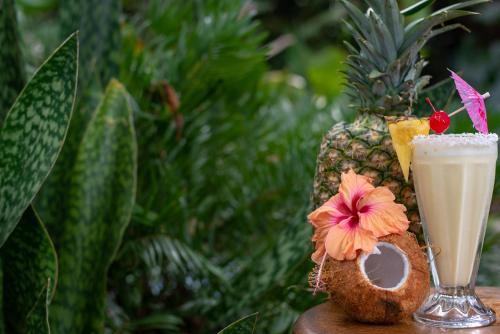 a drink on a table next to a pineapple at Hotel Banana Azul - Adults Only in Puerto Viejo
