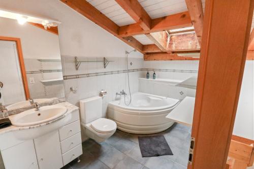 a bathroom with a toilet and a tub and a sink at Joli duplex avec piscine in Cournillens
