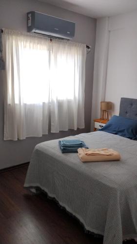 a bedroom with a large bed with a window at Departamento Tigre luminoso frente a club Acohaj in Tigre