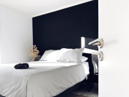 um quarto com uma cama branca e uma cabeceira preta em Departamento Centro moderno con balcón em Temuco